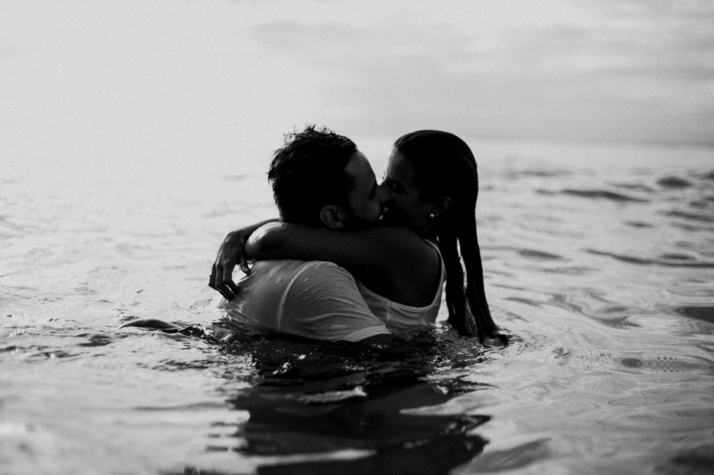 man and woman kissing together on body of water 1001445